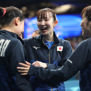 卓球女子団体で日本はドイツを破って決勝進出を決めた。チーム最年少の張本美和（左）を早田ひな（中）と 平野美宇が激励する（写真・ロイター/アフロ）