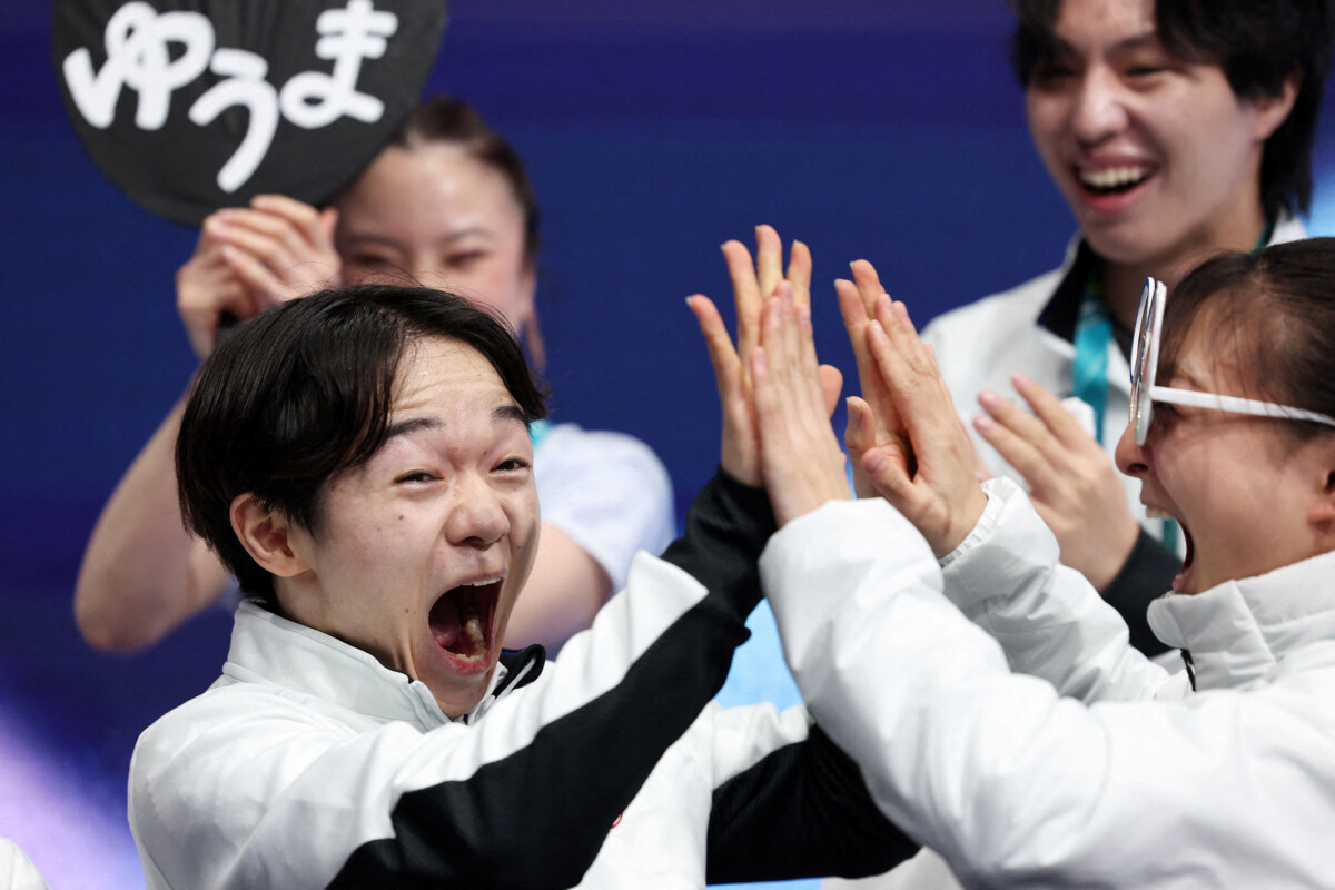 鍵山優真はノーミスで団体男子シングルＳＰでトップに立ちメンバーと喜びを分かち合う（写真・ロイター/アフロ）