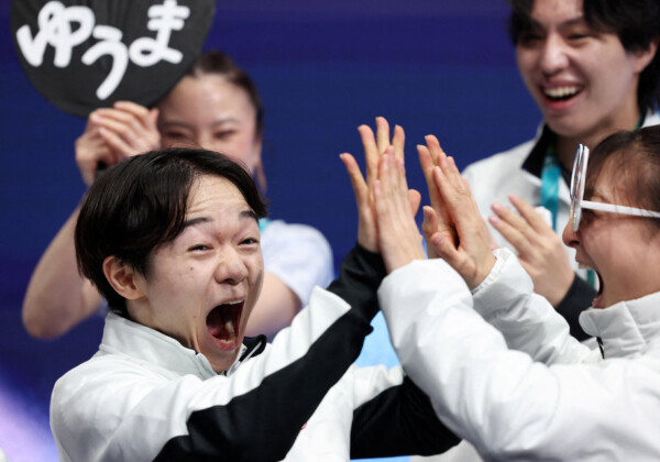 鍵山優真はノーミスで団体男子シングルＳＰでトップに立ちメンバーと喜びを分かち合う（写真・ロイター/アフロ）