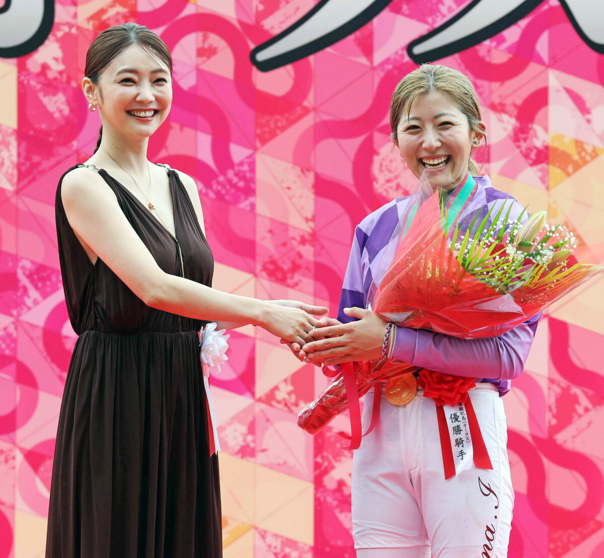 オークスを制してゲストプレゼンターの倉科カナ（左）に祝福される今村聖奈騎手（右）（写真・スポーツ報知/アフロ）