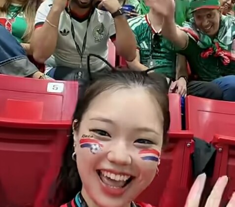 韓国の人気美人ユーチューバの後ろで人種差別的な「つり目ポーズ」をとるメキシコ人男性。この映像が拡散され炎上騒ぎに（Incocat_tのYoutubeより）